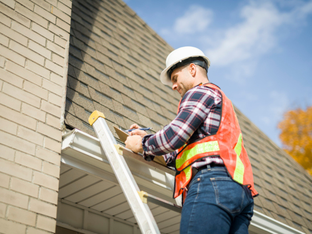 Western Canadian contractor inspecting residential roof to illustrate the importance of liability insurance