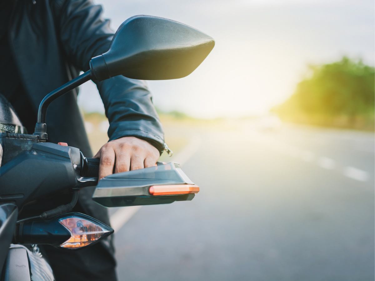 Close-up of a Motorcycle rider gripping the handlebar on an open road