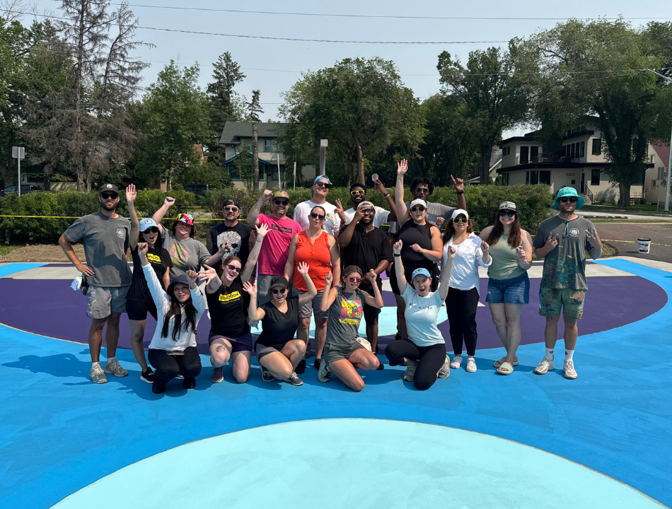 A large group cheers on the painted basketball court.
