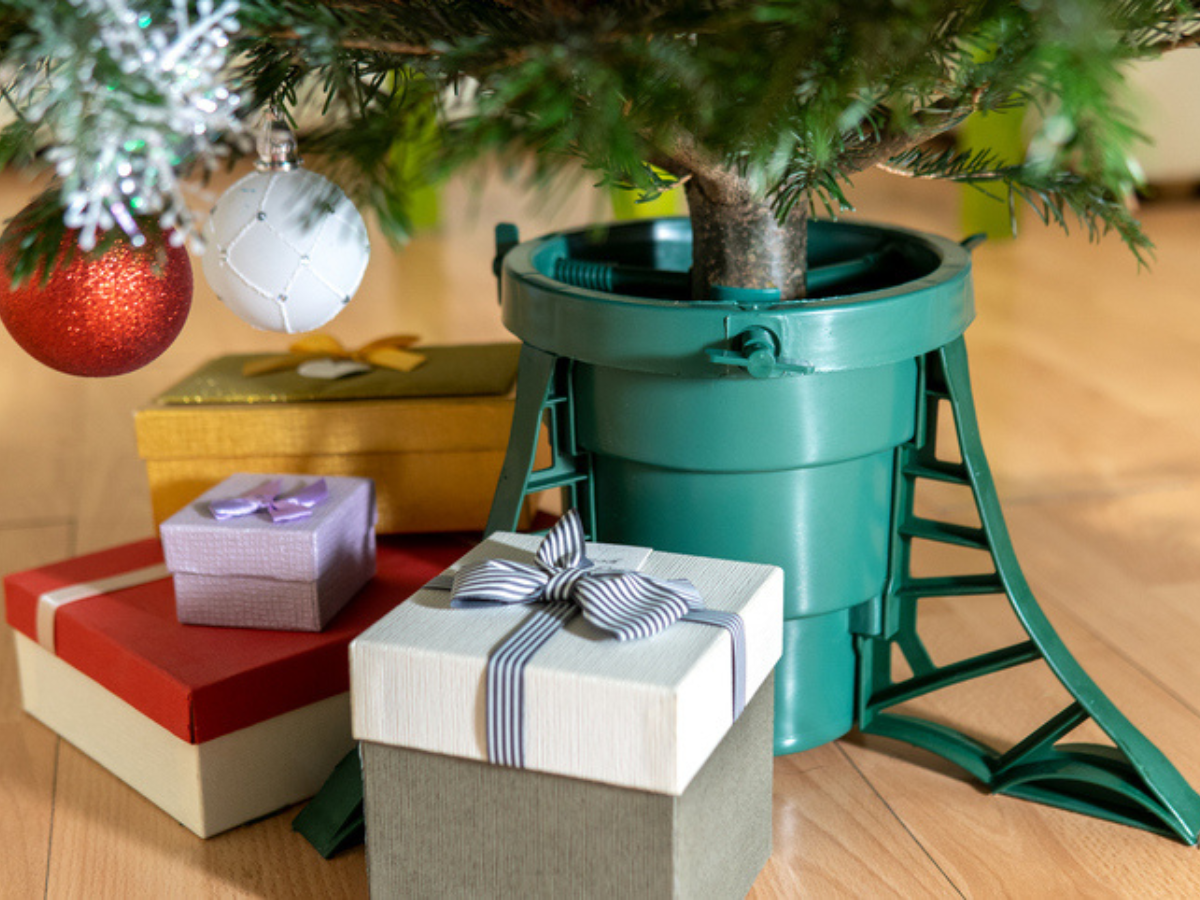 Natural Christmas tree in stand with presents around it