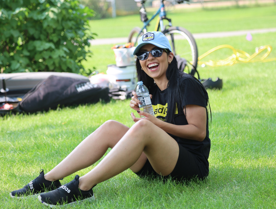 Lisa Mazurin sits in the grass with a joyful expression.
