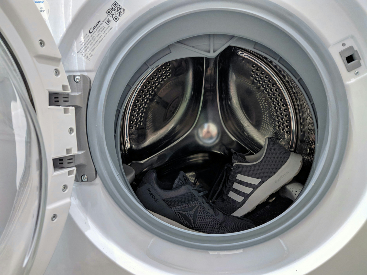 Close-up of running shoes inside a front-load machine using a Dodge Dryer drying method.
