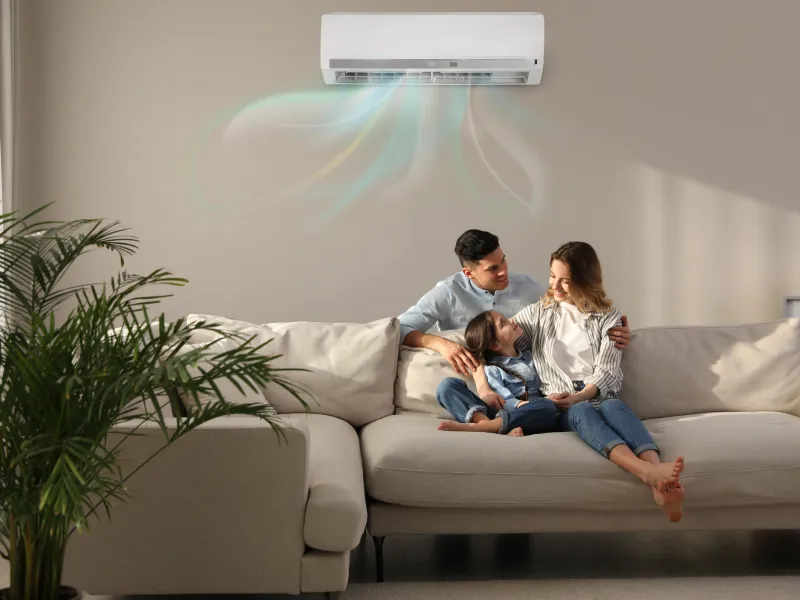 Family Sitting Under Air Conditioning