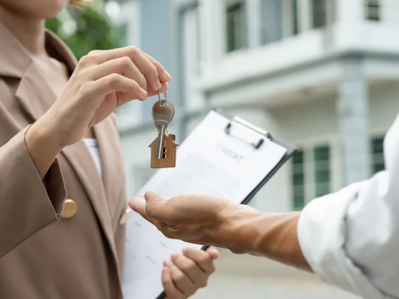 Landlord handing over apartment keys to new tenant during rental agreement signing, representing tenant insurance coverage, renter coverage, and apartment insurance protection.